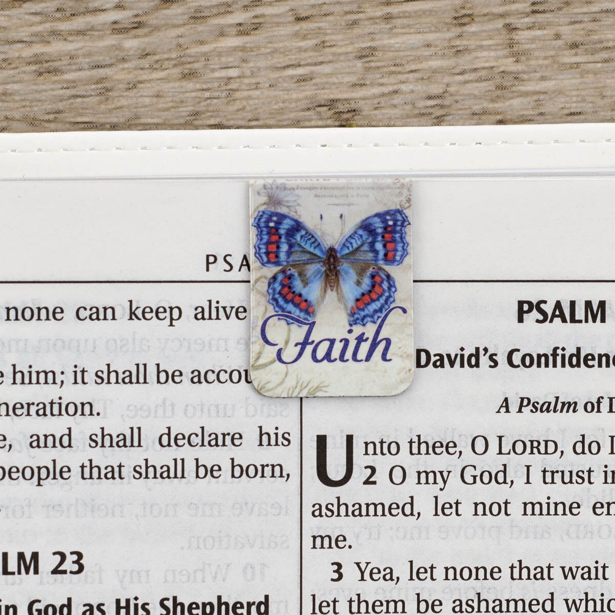 Faith butterfly magnetic bookmark clipped on Bible showing how bookmark securely holds page - mini magnetic bookmark set perfect for marking Scripture passages during Bible study and devotional time