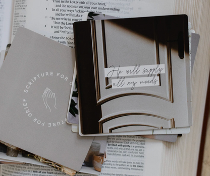 Scripture for Grief verse card displaying 'He will supply all my needs' placed on open Bible, encouraging faith-based comfort card from grief scripture card set