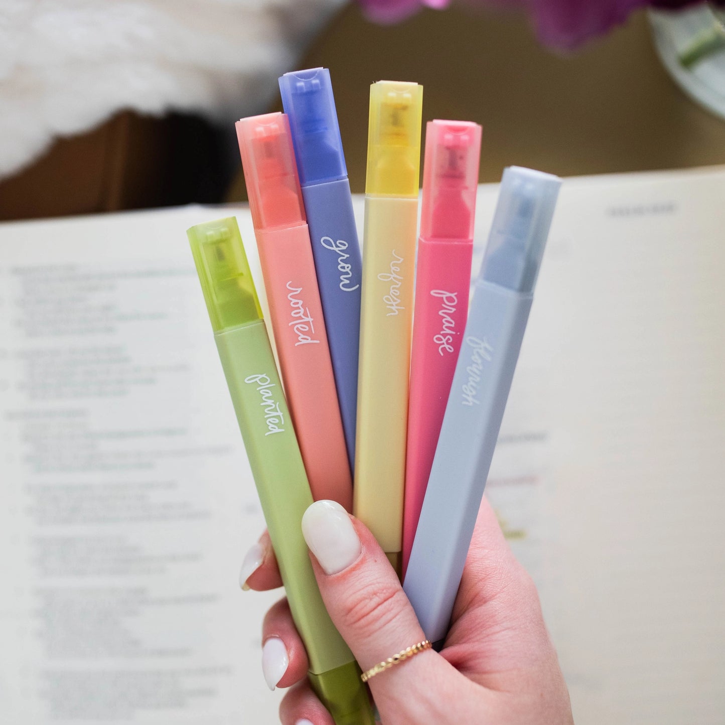 Hand holding all 6 colors of the Garden Highlighter Set spread out included in Fear Not Teen Girl Blessing Box
