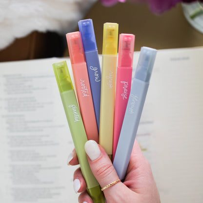 Hand holding all 6 colors of the Garden Highlighter Set spread out included in Fear Not Teen Girl Blessing Box