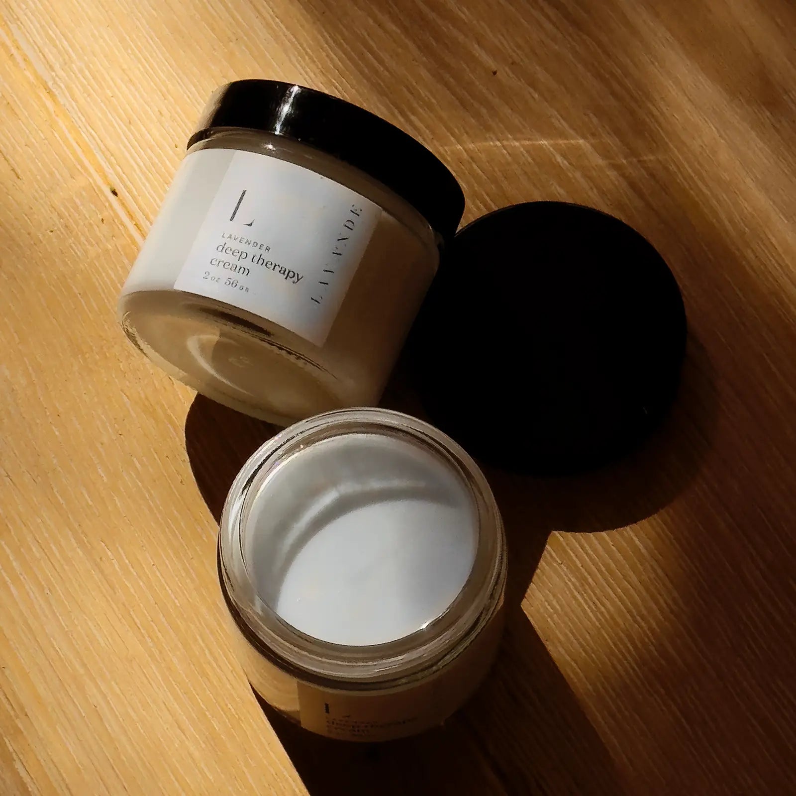 Lavande Two jars of Mini Deep Therapy Cream 2oz — one open to show the cream, one on its side with label facing up, included in Walk by Faith Women's Blessing Box